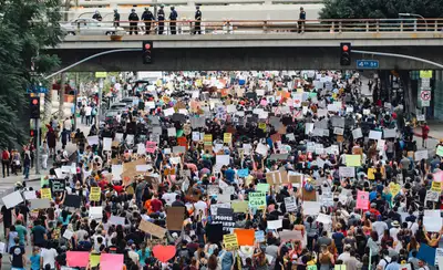 Protesters holding up signs at a large rally