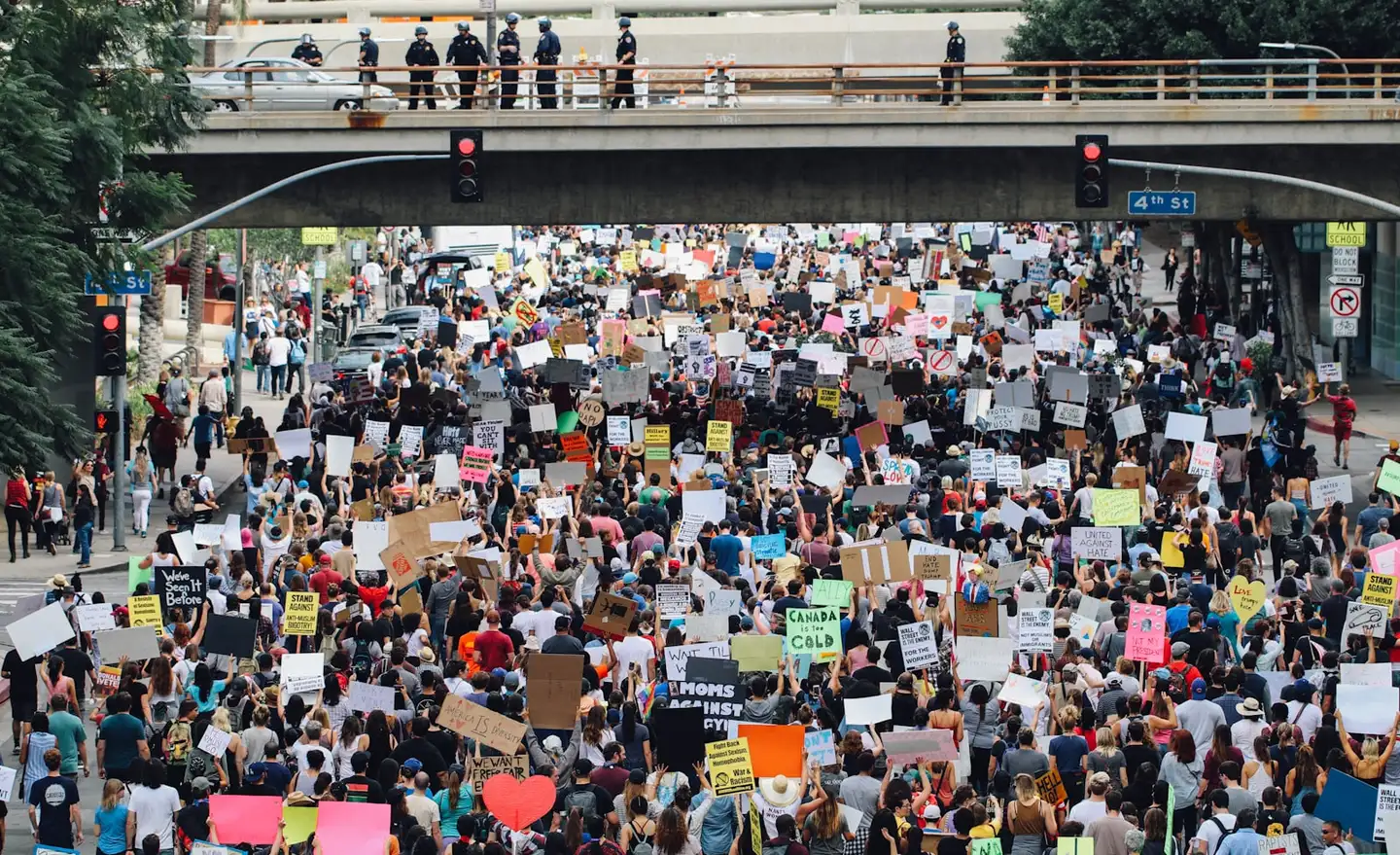 Protesters holding up signs at a large rally