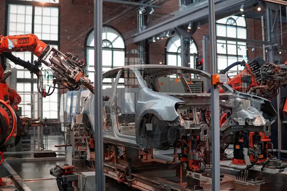 Robotic arms assemble a vehicle on an automotive factory line.