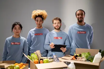 Volunteers in matching sweaters organizing boxes of food donations