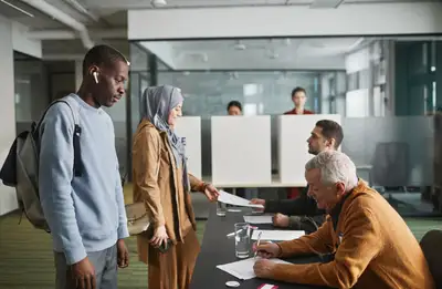 A diverse group of people casting ballots at an indoor polling station