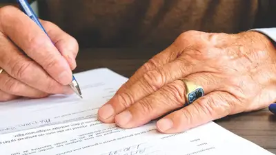 A hand signing a legal document with a pen
