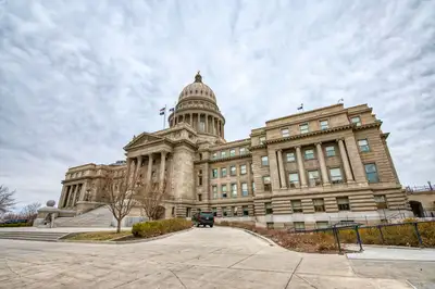A state capitol building with its dome under a cloudy sky