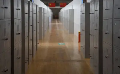 An empty school hallway lined with rows of metal lockers
