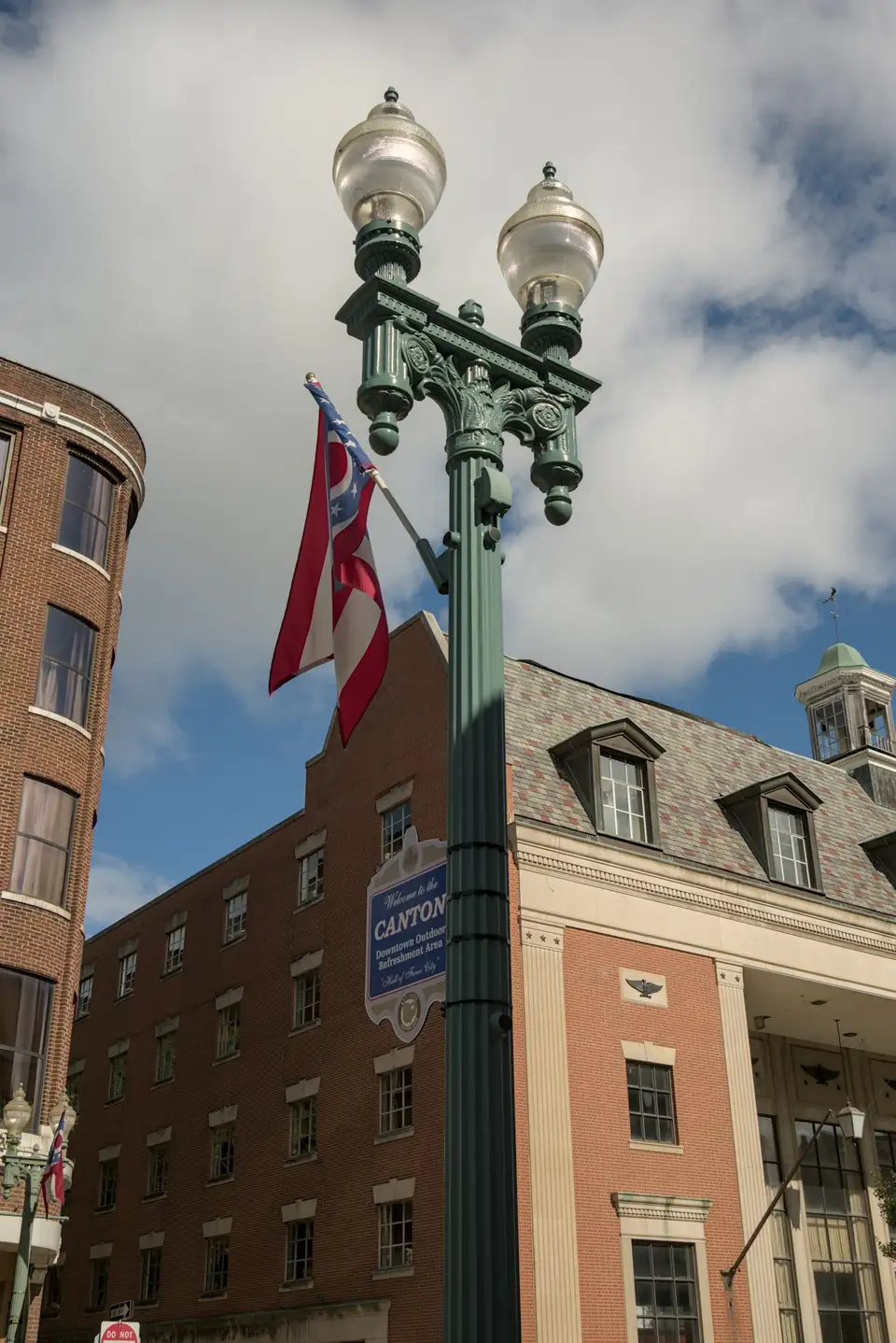 Ornate lamppost with American flags in front of downtown Canton, Ohio buildings