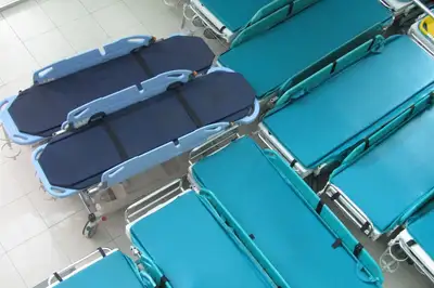 Empty chairs and a bed in a hospital emergency room
