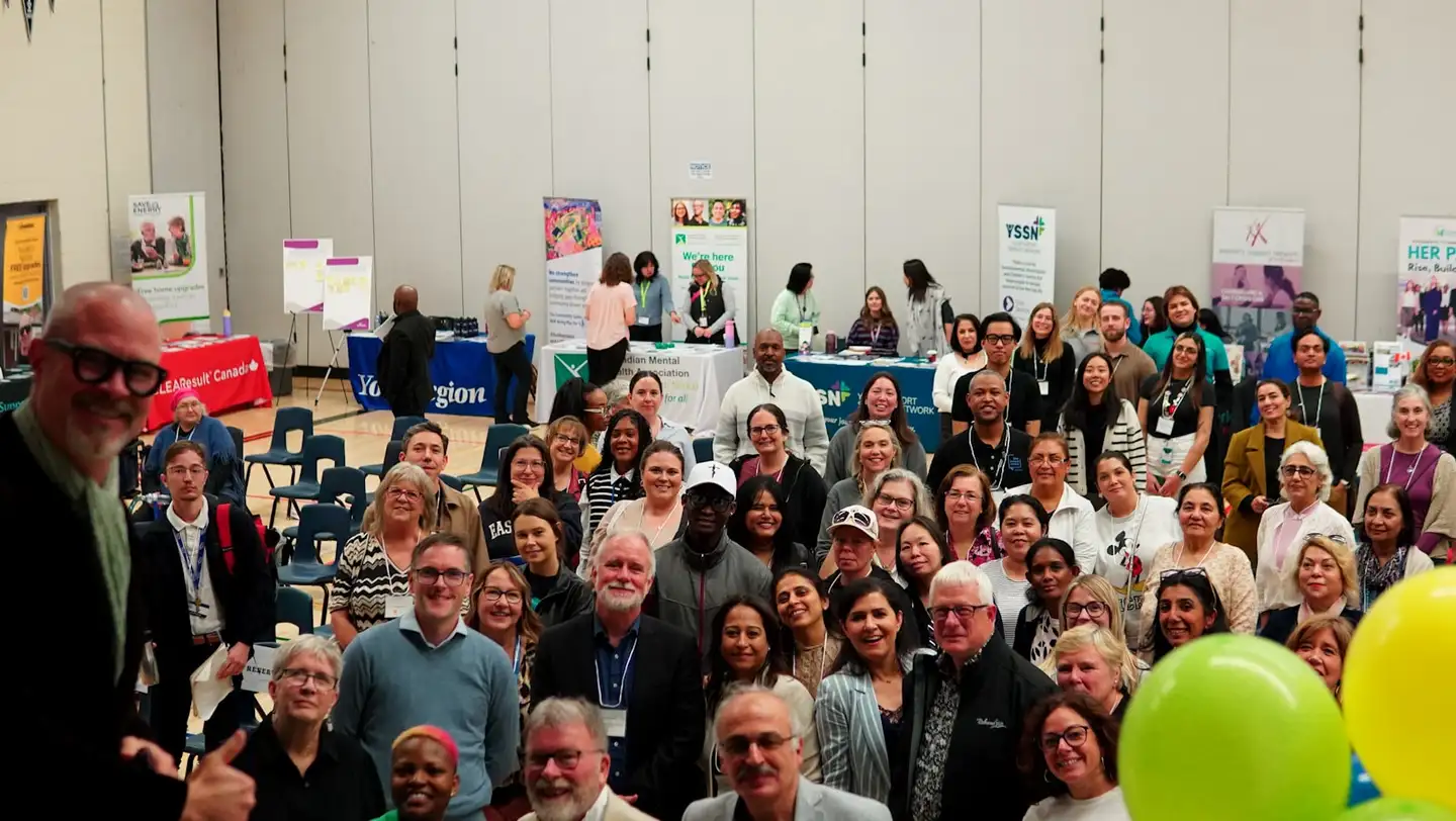 A large group of people gathered indoors at a community event