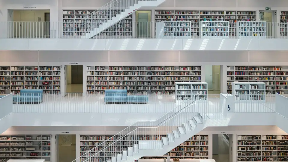 Modern library interior with many bookshelves and stairs