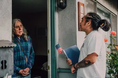 A volunteer talking with a resident during a door-to-door canvass