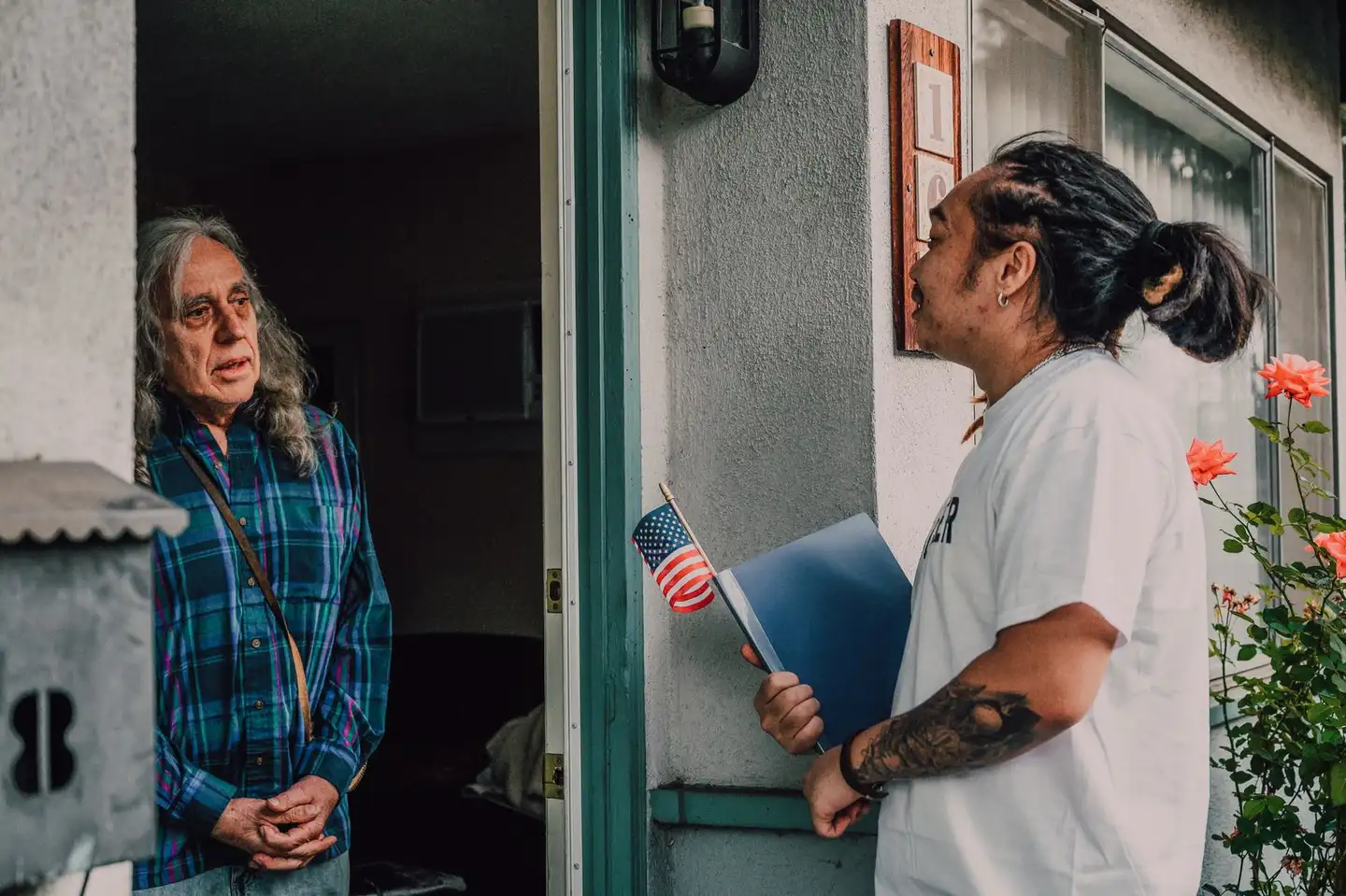 A volunteer talking with a resident during a door-to-door canvass